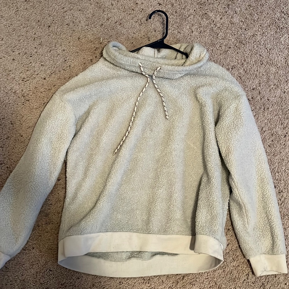 A white scoop neck sweater with draw strings